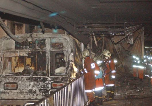 소방대원들이 대구지하철 화재 현장에서 전소된 전동차를 살펴보고 있다. [연합]