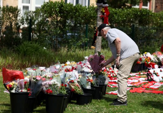 영국의 한 축구팬이 리버풀 홈구장 안필드 스타디움 앞에 디오주 조타의 죽음을 추모하는 꽃다발을 놓고 있다.   [로이터]