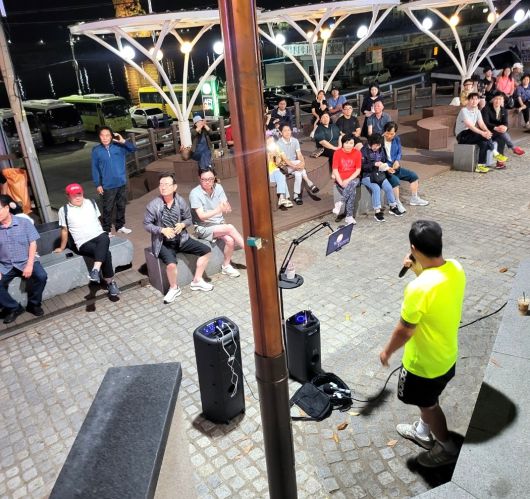 울릉 쿠팡맨으로 알려진 김수현씨가 재능기부 버스킹 공연으로 관광객들이 즐거워 하고 있다.[독자제공]