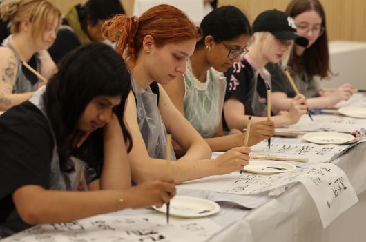 지난 9일 오전 부산 금정구 부산대 인덕관에서 열린 부산대학교 ‘서머 스쿨’에 참가한 해외 대학 학생들이 서예를 체험하고 있다. [연합]