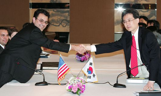 2007년 3월 26일, 대한민국 서울 그랜드하얏트호텔에서 당시 미국 무역대표부 부대표 카란 바티아(왼쪽)가 자유무역협정(FTA) 회담을 앞두고 김현종 한국 통상교섭본부장과 악수하고 있다. [게티이미지]