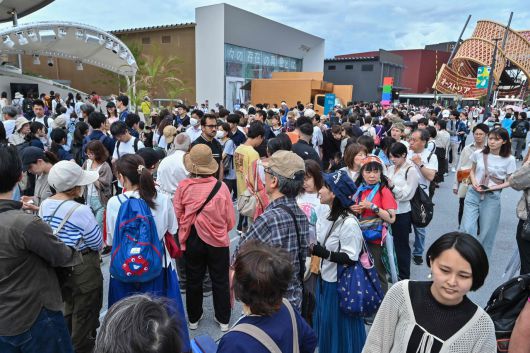 지난 5월 21일(현지시간) 일본 오사카시에서 열린 2025오사카·간사이 만국박람회(오사카 엑스포)의 여러 전시관 앞에 사람들이 줄을 서서 입장을 기다리고 있다.[AFP]