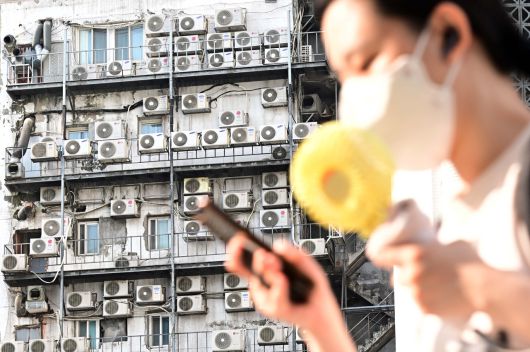 연일 푹푹 찌는 폭염으로 서울 지역이 10일째 열대야가 이어지는 가운데 9일 오전 한 시민이 서울 중구 남대문 인근에 있는 건물 외벽에 줄지어 걸린 에어컨 실외기 앞을 지나가고 있다. 이상섭 기자