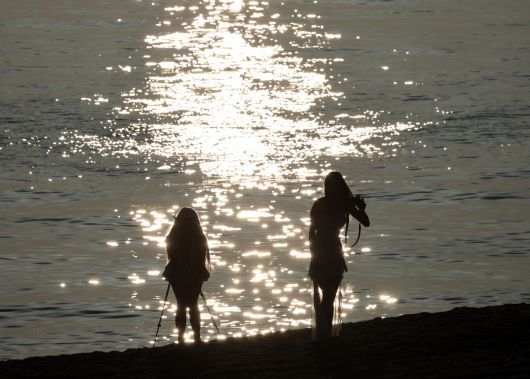 강원 강릉지역에 열대야가 계속된 21일 일출 시각 한껏 차려입은 동남아 관광객들이 경포해수욕장에서 추억을 남기는 사진을 찍고 있다.[연합]