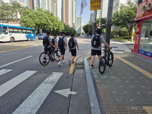 21일 서울 마포구 한 도로에서 학생들이 자전거를 이끌고 하교하고 있다. 김도윤 기자