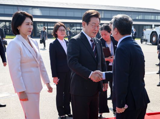 한일 정상회담을 마친 이재명 대통령과 부인 김혜경 여사가 24일 일본 도쿄 하네다공항에서 도널드 트럼프 미국 대통령과의 한미 정상회담을 위해 워싱턴DC로 향하며 환송 나온 인사들과 악수하고 있다. [연합]