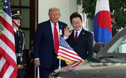 이재명 대통령이 25일(현지시간) 미국 워싱턴DC 백악관에서 영접나온 도널드 트럼프 미국 대통령과 기자들을 바라보며 손을 흔들고 있다. [연합]