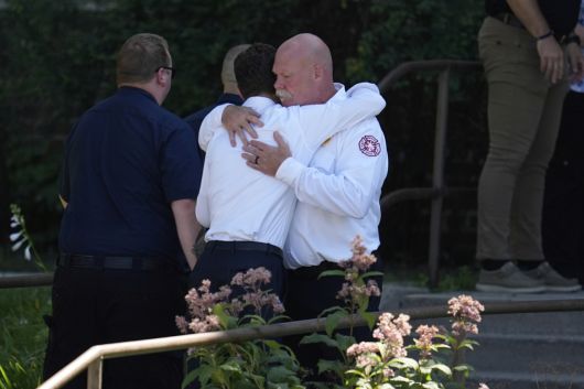 제이컵 프레이 미네아폴리스 시장(왼쪽)이 8월 27일(현지시간) 미네아폴리스의 애너운시에이션 교회 부속 학교 밖에서 총격 사건 이후 출동한 구조대원들과 포옹하고 있다. [AP]