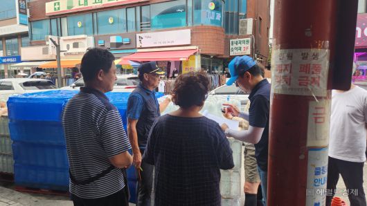 지난 2일 강릉 중앙시장 입구에서 상인들이 물을 배급받기 위해 모여있는 모습. 안효정 기자.