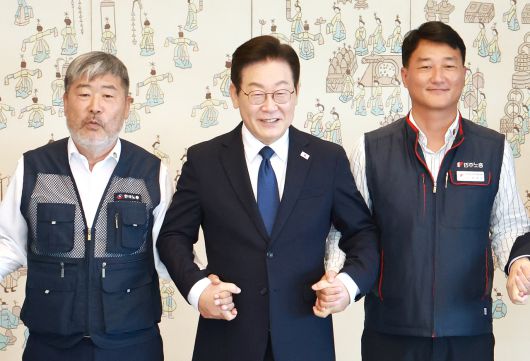 이재명 대통령이 4일 서울 용산 대통령실 청사에서 열린 양대노총 위원장과의 오찬 간담회에 참석해 김동명 한국노총 위원장(왼쪽), 양경수 민주노총 위원장과 기념촬영을 하며 손을 잡고 있다. [연합]