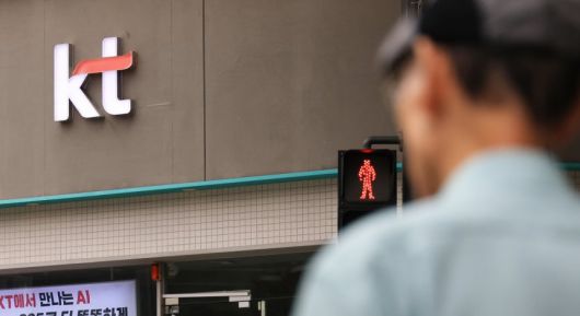 한 시민이 서울의 한 KT 판매점 앞을 지나고 있다.  [연합]