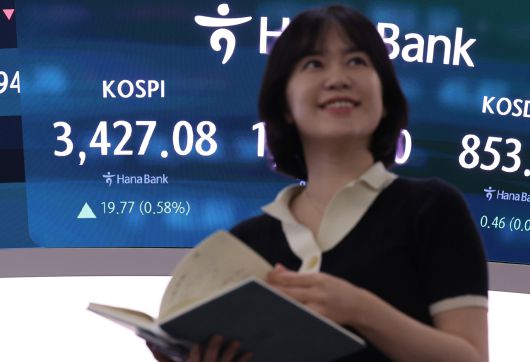 코스피가 상승 출발한 16일 서울 중구 하나은행 딜링룸에서 한 딜러가 활짝 웃고 있다. [연합]