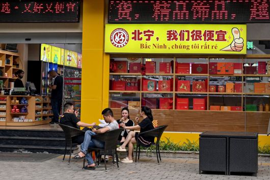 베트남 박닌성에 위치한 차이나타운의 한 편의점 앞에 사람들이 앉아 있다. [AFP]