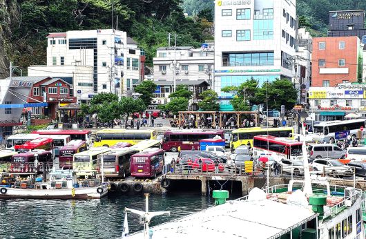 한산하던  도동항 여객선 터미널 인근 해변공원이 관광버스와 관관객으로  붐비고 있다.[울릉군 제공]