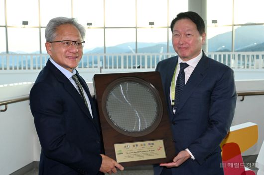 젠슨 황(왼쪽) 엔비디아 최고경영자(CEO)가 31일 경북 경주시 경주예술의전당에서 열린 APEC CEO 서밋 2025에 참석해 최태원 SK그룹 회장 겸 대한상공회의소 회장으로부터 SK하이닉스의 HBM4 반도체 웨이퍼를 선물로 받고 있다. 경주=임세준 기자