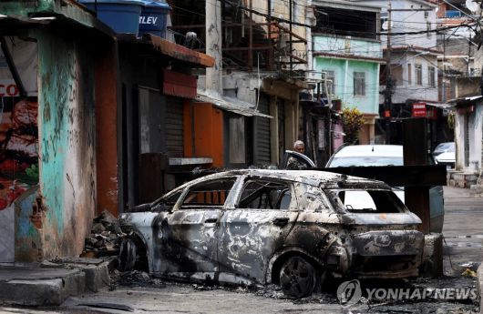 28일(현지시간) 브라질 갱단 해체 작전지 내 불에 탄 자동차 [연합]