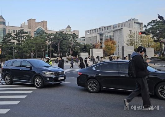 4일 오전 서울 서대문구 연세대 교차로에서 보행자들이 꼬리물기 차량을 피해 길을 건너고 있다. 이용경 기자