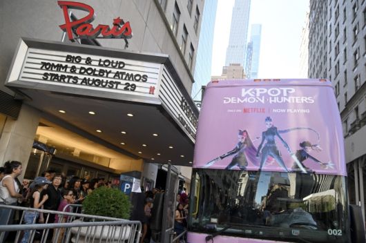 지난 8월 ‘케이팝 데몬 헌터스’ 싱어롱 상영을 홍보하는 포스터가 장식된 2층 버스가 미국 뉴욕의 한 극장 앞에 서 있다. [로이터]