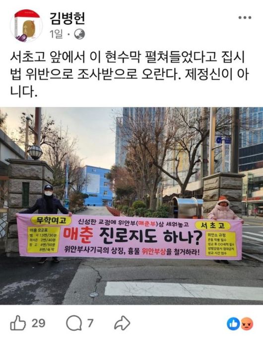 김병헌 위안부법폐지국민행동 대표가 올린 지난달 29일 서초고 앞 현수막을 펼쳐 찍은 사진. 해당 현수막에는 “매춘 진로지도 하니?”라는 내용이 담겨있다. [페이스북 캡처]