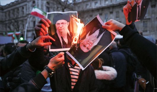 11일(현지시간) 영국 런던 다우닝가 외곽에서 열린 이란 시위 운동 집회에 참여한 시위대가 아야톨라 알리 하메네이 이란 최고 지도자의 초상을 불태우고 있다. [로이터]