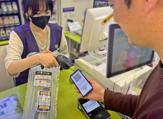 고객이 포켓CU 앱으로 사전 예약한 제품을 받고 있다. [CU 제공]