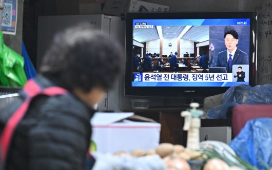 16일 오후 서울 서대문구 인왕시장 내 점포에서 상인이 윤석열 전 대통령의 체포방해 등 혐의 사건에 대한 1심 선고 중계방송을 시청하고 있다. 임세준 기자