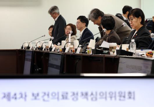 정은경 보건복지부 장관(사진 맨 오른쪽)이 지난 20일 서울 서초구 국제전자센터에서 열린 제4차 보건의료정책심의위원회에서 자료를 살펴보고 있다.[연합]