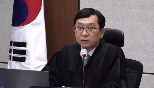 21일 서울중앙지법에서 열린 한덕수 전 국무총리의 내란 중요임무 종사 혐의 1심 선고 공판에서 이진관 부장판사가 발언하고 있다. [연합]