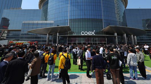 25일 건물내 입점한 식당에서 화재가 발생한 서울 강남구 코엑스 앞에 긴급 대피한 시민들이 모여 있다.