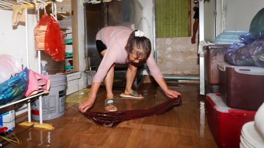 호우경보가 발효된 17일 오전 광주 남구 백운광장 인근 미용실이 물에 잠겨 업주가 배수 작업을 하고 있다.