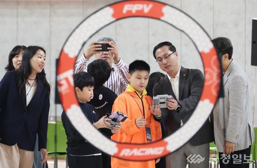 박희조 동구청장이 직접 조종기를 잡고 아이들과 함께 비행을 시도하며 미래기술 체험에 나서고 있다
