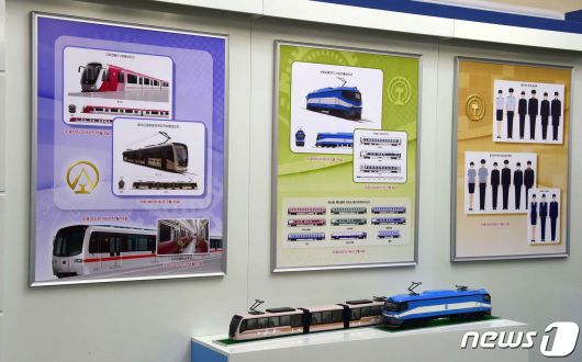 북한 국가산업미술전시회에 출품된 교통운수 부문 도안들과 그 모형들. 사진의 좌측 하단에 김정은 위원장이 2015년 시운전에 탑승한 평양 <지하전동차 1호> 형태도안이 보인다. (대외 선전매체 '서광' 갈무리)© 뉴스1