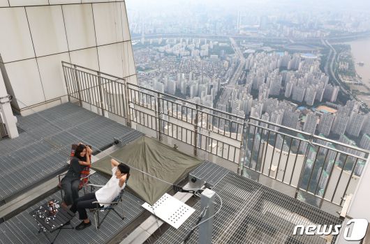 7일 서울 잠실 롯데월드타워 123층 534m 높이에 마련된 '비박존'에서 유튜버 윤재원씨와 배희준씨가 캠핑을 즐기고 있다. 2020.8.7/뉴스1 © News1 임세영 기자