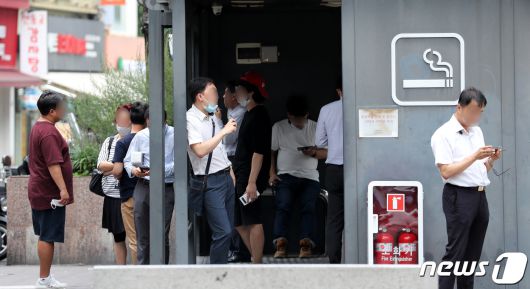 지난달 24일 오후 서울시내의 한 흡연부스에서 흡연자들이 마스크를 벗은 채 흡연을 하고 있다. 2020.8.24/뉴스1 © News1 박지혜 기자