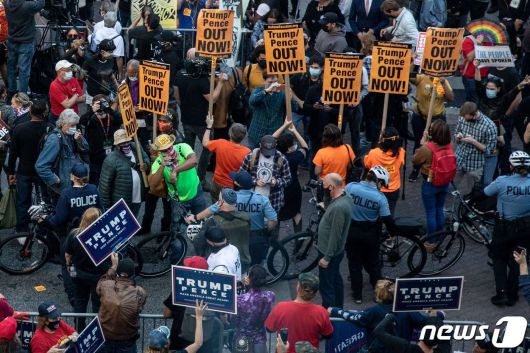 필라델피아의 한 개표소 앞에서 바이든 후보 지지자들과 트럼프 대통령 지지자들이 각각 집회를 열고 있다. 두 집회 사이에는 충돌을 방지하기 위해 경찰이 배치됐다. © AFP=뉴스1