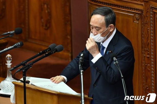 스가 요시히데 일본 총리가 지난 18일 의회 연설 도중 마스크를 고쳐 쓰고 있다. © AFP=뉴스1
