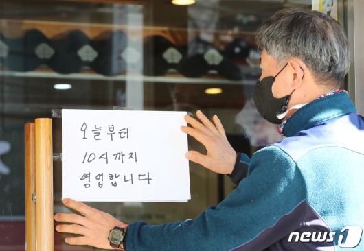 정부가 총 19조 5000억원 규모의 4차 재난지원금을 지급할 예정인 가운데  대전·충남지역민들은 다양한 반응들을 내놓고 있다. 사진은 비수도권 지역 다중이용시설 영업시간이 오후 10시까지 연장된 지난 2월8일 오후 대전 서구 한 식당 주인이 10시까지 영업한다는 안내문을 붙이고 있다. © News1 김기태 기자