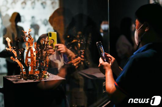 6일 서울 중구 국립현대미술관 덕수궁관에서 열린 'DNA: 한국미술 어제와 오늘' 언론공개회에서 취재진이 보물 339호 서봉총 신라금관에 대한 설명을 듣고 있다. '한국의 미란 무엇인가'라는 질문에서 시작한 이번 전시는 동아시아 미학의 핵심이자 근현대 미술가들의 전통 인식에 이정표 역할을 해온 네 가지 키워드 성(聖, Sacred and Ideal), 아(雅, Elegant and Simple), 속(俗, Decorative and Worldly), 화(和, Dynamic and Hybrid)를 중심으로 펼쳐지며 오는 10월 10일까지 열린다. 2021.7.6/뉴스1 © News1 안은나 기자