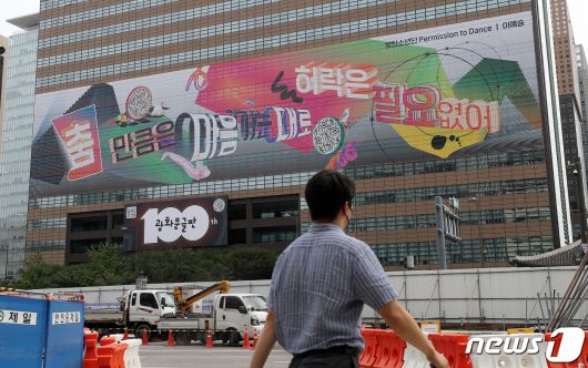 30일 오전 100번째 광화문글판이 걸려있는 서울 종로구 교보빌딩 앞으로 시민들이 발걸음을 옮기고 있다. 글로벌 아티스트 방탄소년단(BTS)가 100번째 광화문글판을 위해 문안 제작에 참여한 이번 글판은 코로나 펜데믹으로 제약이 늘고 고단한 하루 속에서도 허락받지 않고 자유로움을 느낄 수 있는 것을 찾자는 메시지를 담았다. 2021.8.30/뉴스1 © News1 박세연 기자