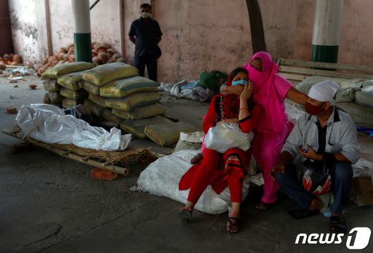 2021년 4월 26일 인도 뉴델리에서 코로나로 숨진 희생자의 시신 옆에서 가족들이 오열하고 있다. © 로이터=뉴스1 © News1 박형기 기자