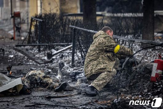 2일(현지시간) 러시아 군의 공습을 받은 우크라이나 키예프의 TV 방송 타워 주변에서 경찰이 행인의 시신을 수습하고 있다. © AFP=뉴스1 © News1 우동명 기자