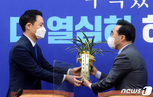 박홍근 더불어민주당 신임 원내대표(오른쪽)가 25일 오전 서울 여의도 국회에서 김한규 대통령비서실 정무비서관에게 문재인 대통령의 축하 난을 받고 있다. 2022.3.25/뉴스1 © News1 이동해 기자