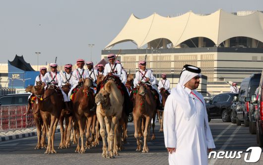 2022 카타르 월드컵 개막식을 앞둔 20일(현지시간) 카타르 알코르 알베이트 스타디움 입구에 낙타를 탄 남성들이 도열해 손님맞이를 하고 있다. 2022.11.20/뉴스1 ⓒ News1 이동해 기자