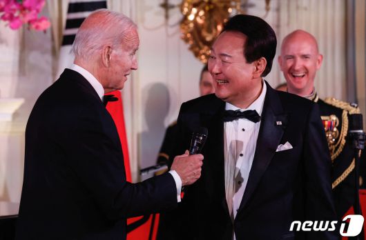 조 바이든 미국 대통령이 26일(현지시간) 워싱턴 DC 백악관에서 열린 윤석열 대통령 국빈 방미 기념 만찬에서 윤 대통령에게 마이크를 건네고 있다. 2023.04.26. ⓒ 로이터=뉴스1 ⓒ News1 김성식 기자