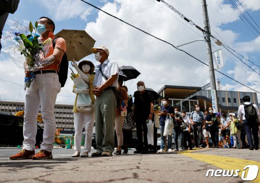 아베 신조 전 일본 총리가 선거 유세중 총에 맞고 숨진 다음날인 9일(현지시간) 일본 나라시에서 시민들이 아베 전 총리가 피격당한 현장에 헌화를 위해 줄을 서고 있다. 2022.07.09 ⓒ 로이터=뉴스1 ⓒ News1 이성철 기자