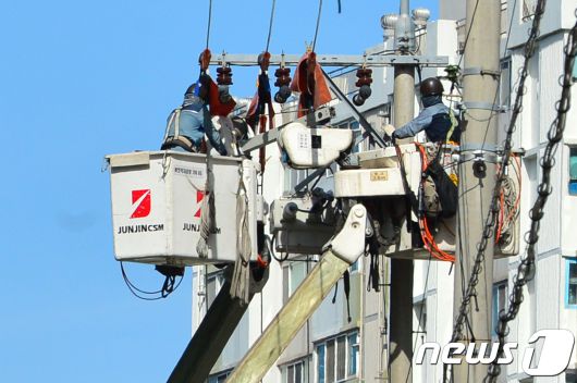 13일 오후 전국 대부분 지역에 폭염주의보가 발령되면서 전기 사용량이 상승하자 한국전력공사 포항지사 기술자들이 북구 장성동 일원에 있는 전신주에서 정전에 대비한 노후 개폐기 교체 공사를 하고 있다.2018.7.13/뉴스1 ⓒ News1 최창호 기자