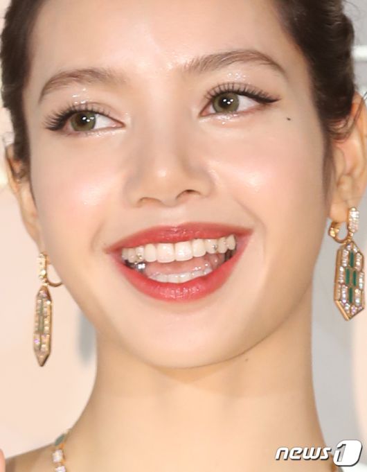 블랙핑크 리사가 28일 오후 서울 종로구 소격동 국제 갤러리에서 진행된 한 명품 브랜드의 컬렉션 75주년 기념 포토월에서 환하게 웃고 있다. 리사의 치아에 은색의 하트와 별 모양의 주얼리가 눈길을 끈다. ⓒ News1 권현진 기자