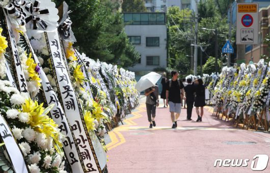 3일 서울 양천구의 한 초등학교에 마련된 교사 A씨의 추모공간을 찾은 추모객들이 근조 화환을 보고 있다. 올해로 14년차 교사인 A씨는 지난달 31일 경기 고양시의 한 아파트에서 극단적 선택으로 숨졌다. 2023.9.3/뉴스1 ⓒ News1 신웅수 기자