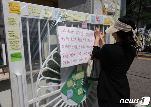3일 서울 양천구의 한 초등학교에 마련된 교사 A씨의 추모공간을 찾은 한 추모객 악성 민원처벌을 촉구하는 문구를 작성하고 있다. 올해로 14년차 교사인 A씨는 지난달 31일 경기 고양시의 한 아파트에서 극단적 선택으로 숨졌다. 2023.9.3/뉴스1 ⓒ News1 신웅수 기자
