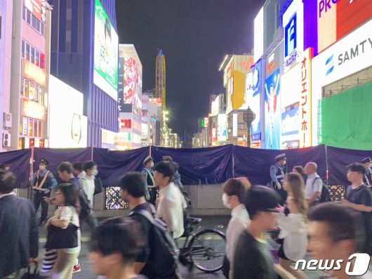 한신 타이거즈가 18년 만에 센트럴리그 정규시즌 우승을 확정지은 14일 밤 일본 오사카 도톤보리강 일대에서 경찰이 야구팬들의 입수를 막고자 천막으로 강 방향을 막고 있다. 일본 경찰은 이날 오사카 대표 관광지인 도톤보리강 주위로 차량 수십대와 인력을 배치해 압사 및 입수 사고에 대비했다. 2023.9.14/뉴스1 ⓒ News1 박정호 기자